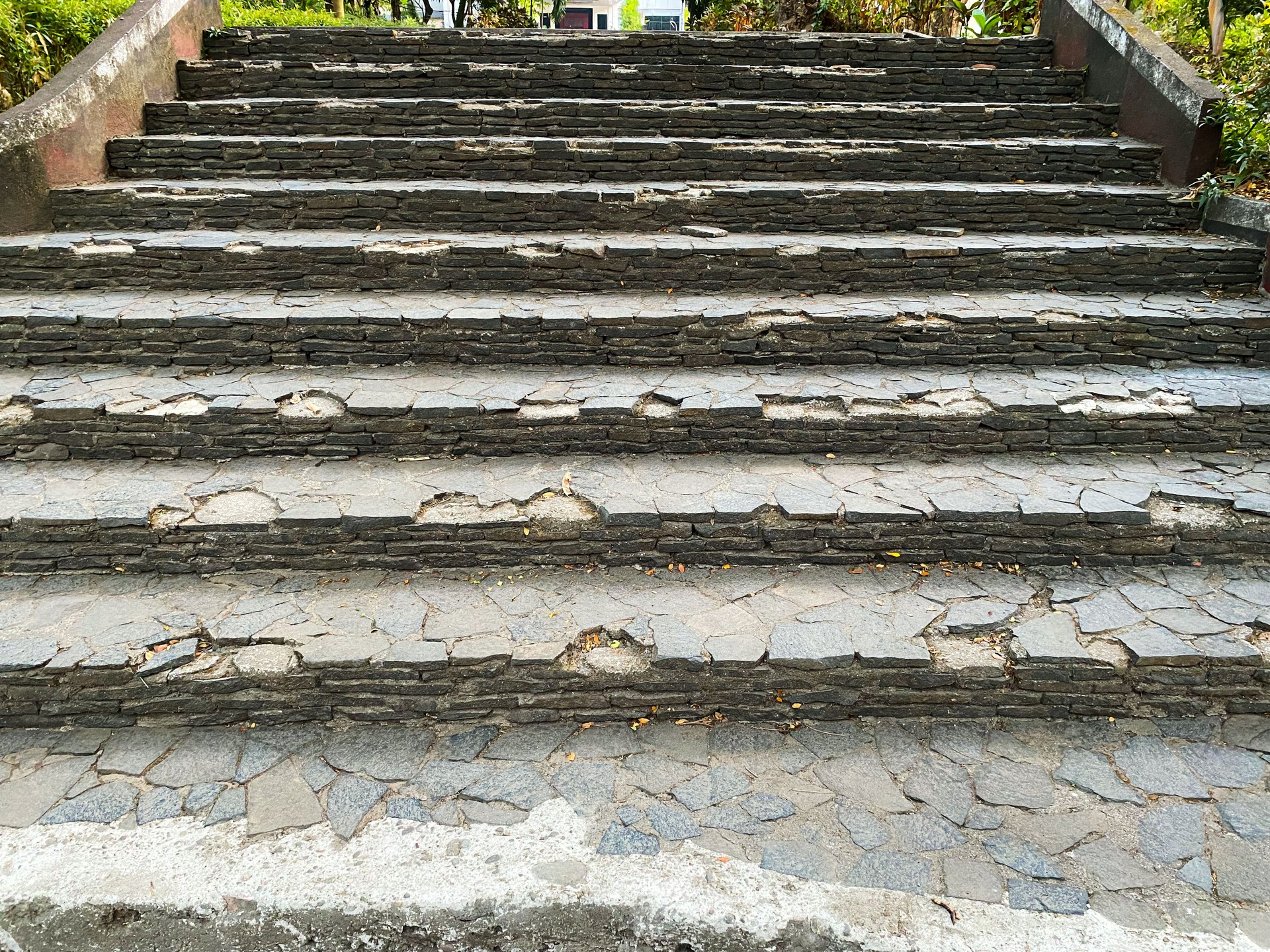 A close-up view of worn stone steps with a rough, stone textured surface.